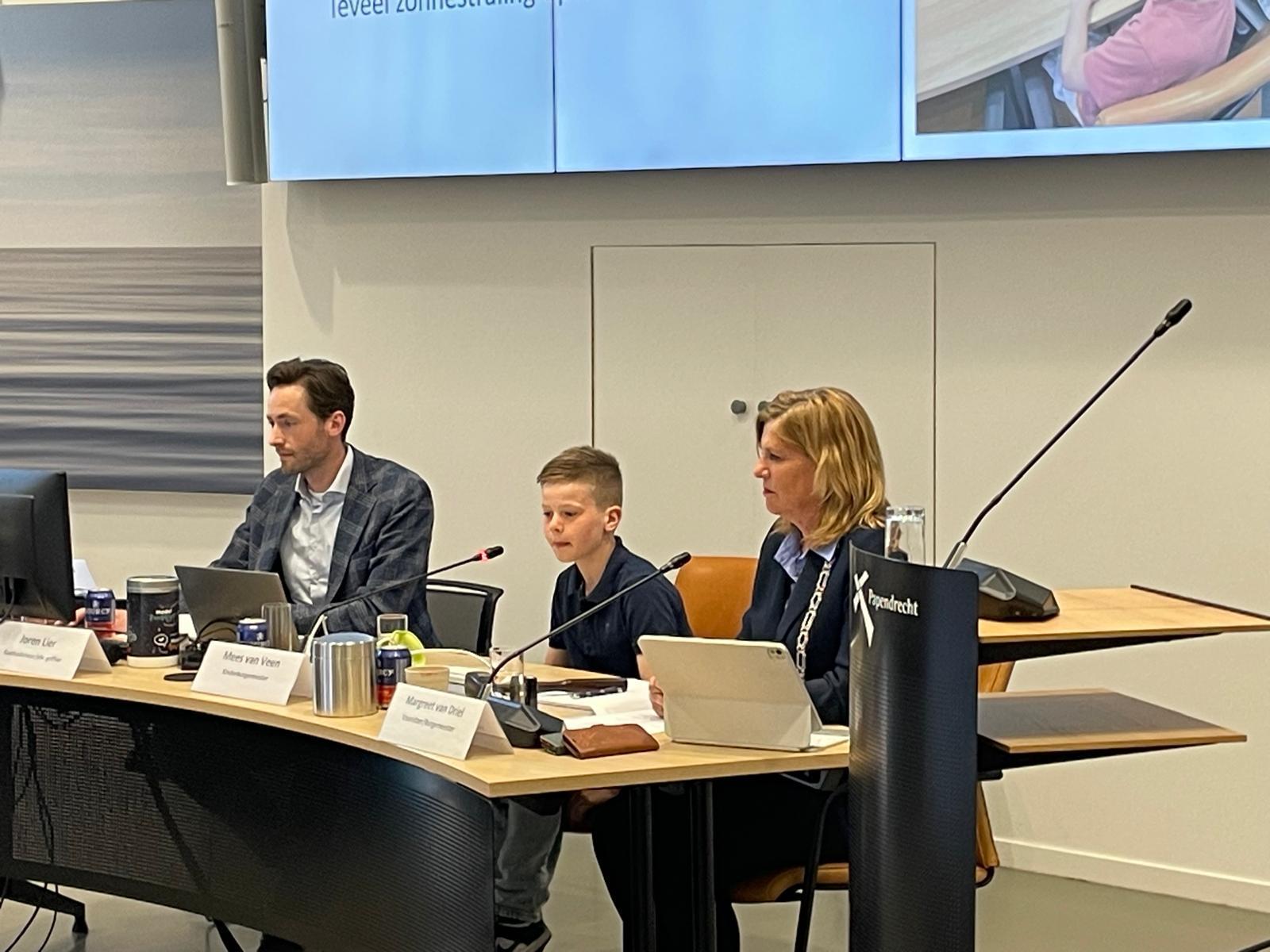 Kinderburgemeester Mees van Veen legt een plan voor aan de gemeenteraad om bezoekers van het buitenzwembad meer bescherming te bieden tegen de zon.